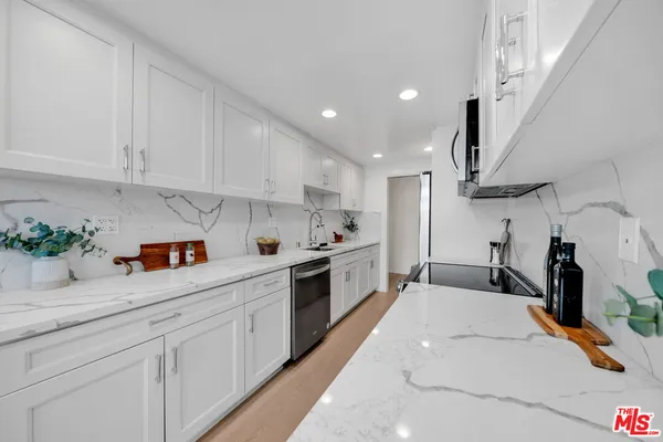 a kitchen with stainless steel appliances granite countertop a sink a stove and cabinets