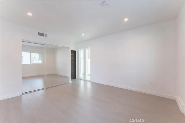 an empty room with window and wooden floor