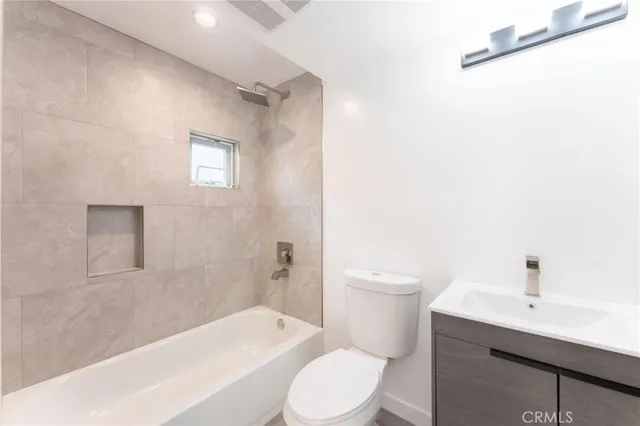 a white toilet sitting next to a bath tub