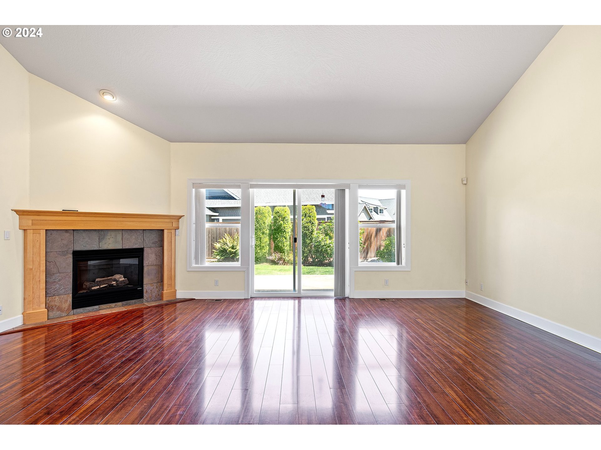790 Old Orchard Lane Springfield, OR 97477 - Photo 6 of 46 a view of an empty room with wooden floor fireplace and a window
