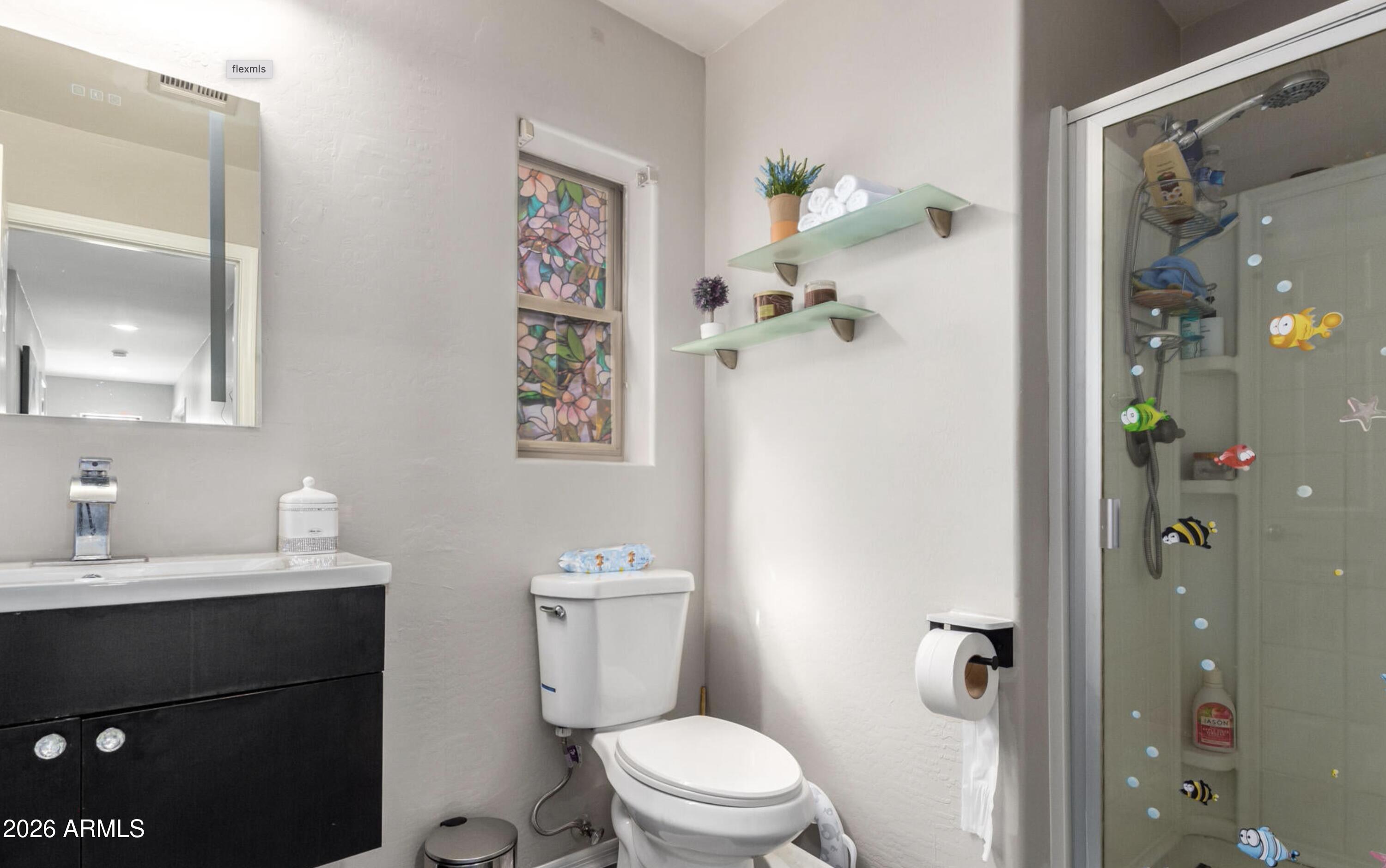 10225 West Camelback Road, Unit 12 Phoenix, AZ 85037 - Photo 12 of 19 a bathroom with a toilet a sink and shower