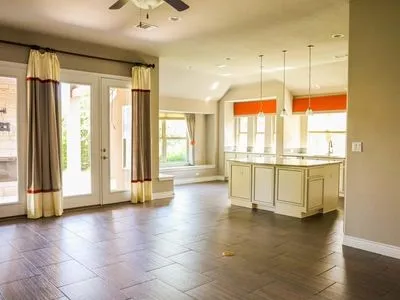a view of a large kitchen with stainless steel appliances granite countertop a stove and a large window