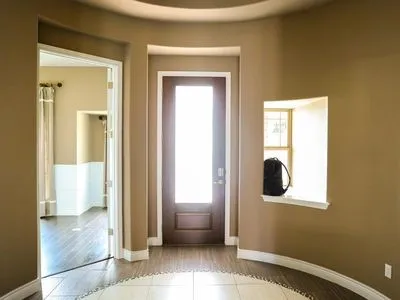 a view of a hallway with wooden floor and a living room