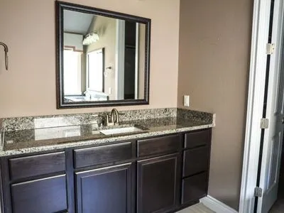 a bathroom with a granite countertop sink and a mirror