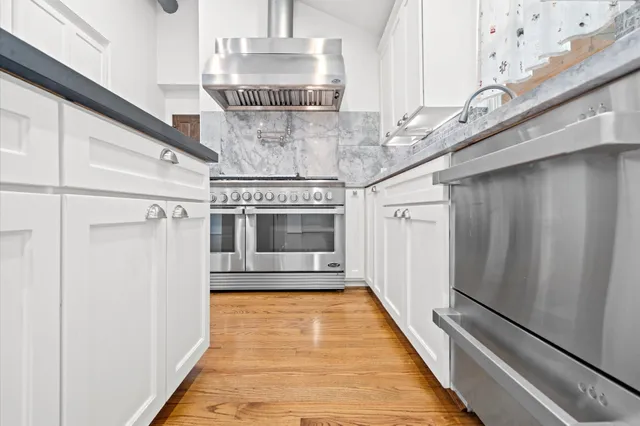 a view of a kitchen with a sink and wooden floor
