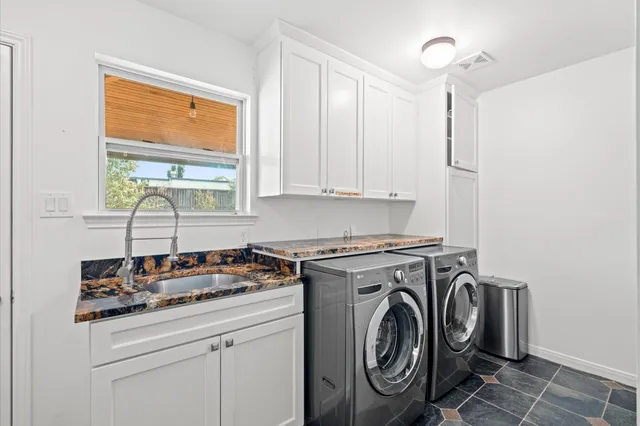 a utility room with sink dryer and washer