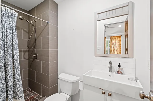 a bathroom with a sink mirror toilet and shower