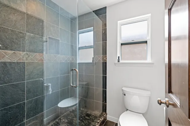 a bathroom with a toilet and a shower