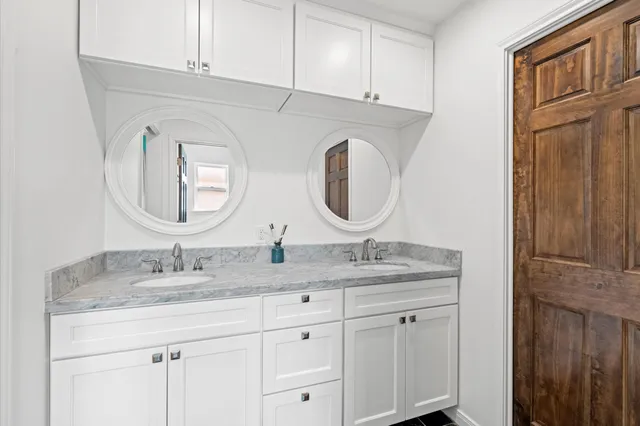 a bathroom with a granite countertop double vanity sinks and a mirror