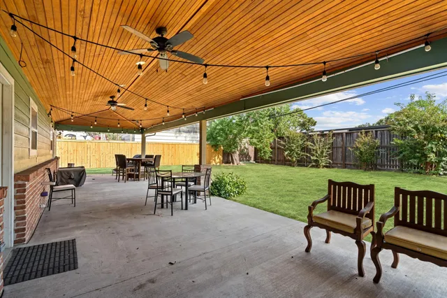 a view of a patio with table and chairs potted plants with wooden floor and fence