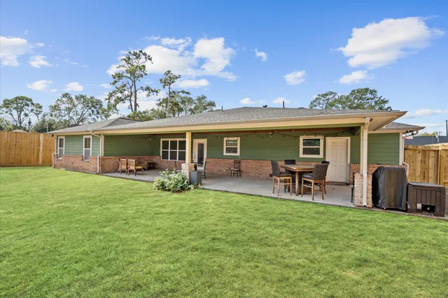a view of a house with a backyard and a patio