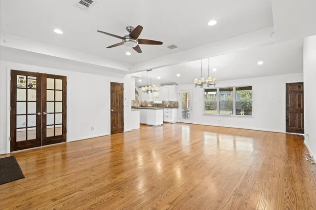 a view of an empty room with window and wooden floor