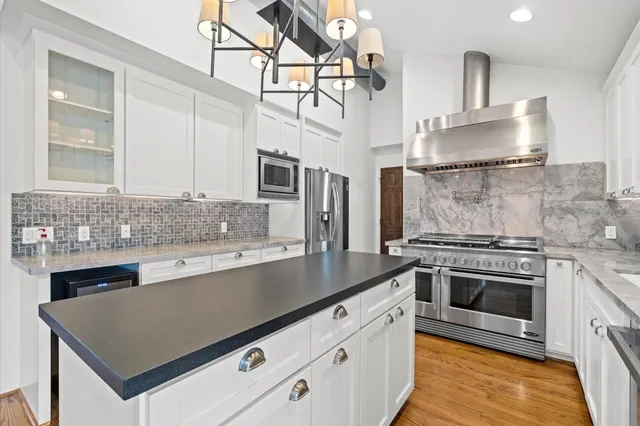 a kitchen with stainless steel appliances granite countertop a sink stove and cabinets