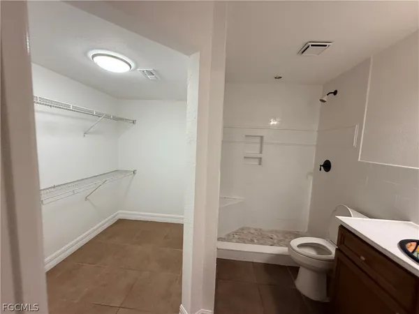a bathroom with a granite countertop toilet a sink and shower