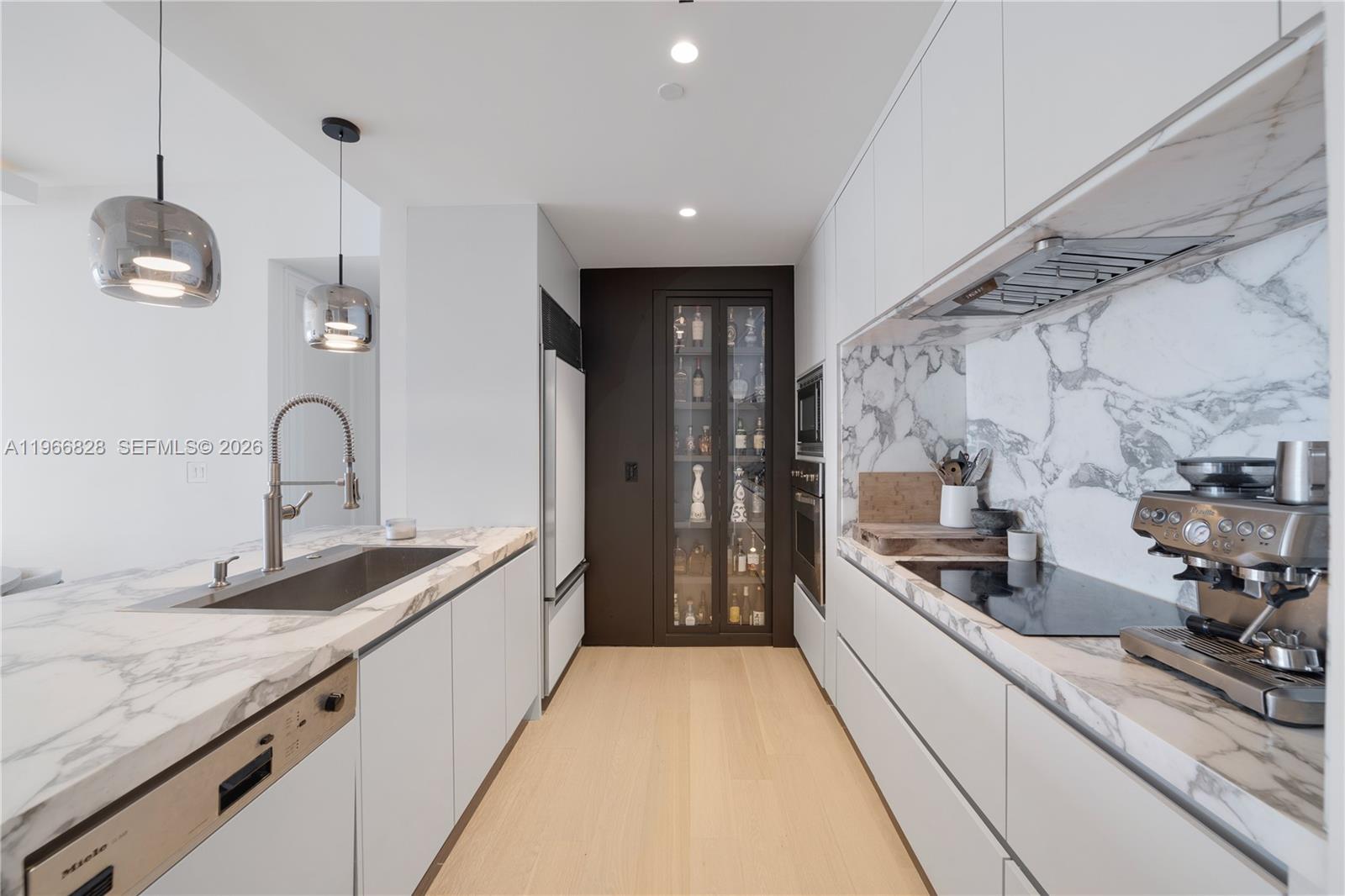 1425 Brickell Avenue, Unit 57A Miami, FL 33131 - Photo 4 of 35 a kitchen with granite countertop a sink and refrigerator