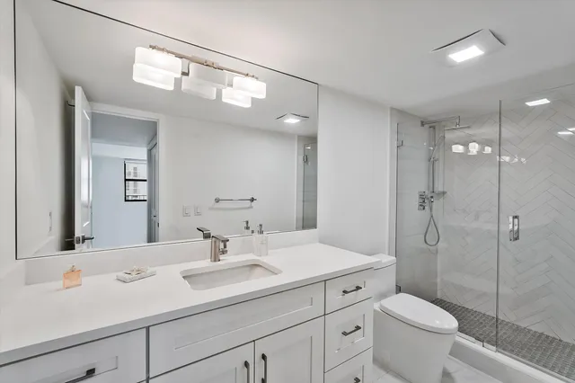 a bathroom with a sink a toilet and shower