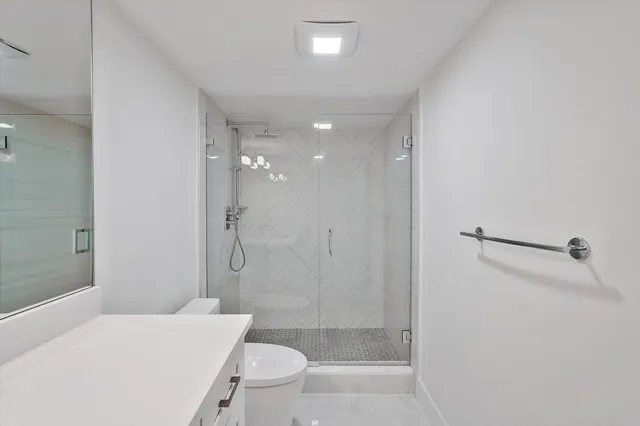 a bathroom with a shower a toilet and sink