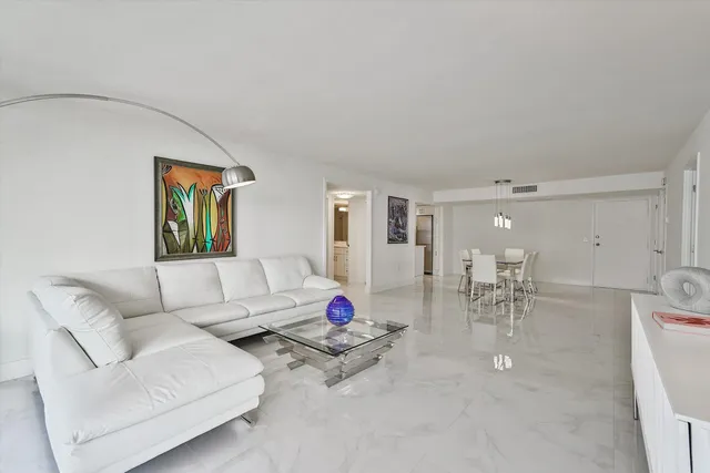 a living room with furniture and a dining table with wooden floor