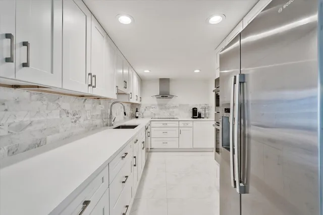 a kitchen with white cabinets and white appliances