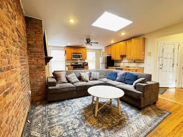 a living room with fireplace furniture and a rug