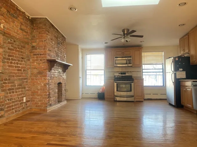 a kitchen with stainless steel appliances a stove a refrigerator and a fireplace