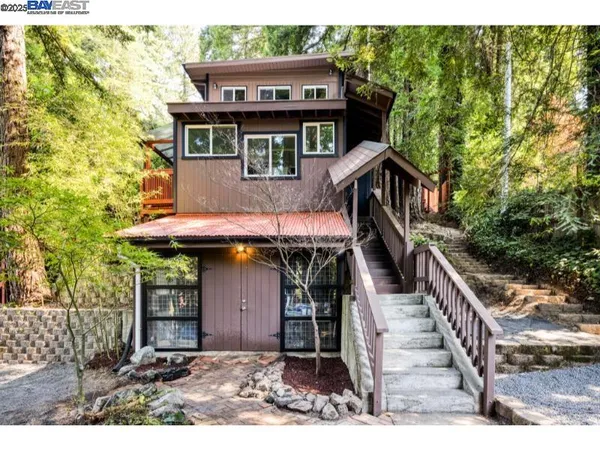 a view of a house with large windows and a small yard