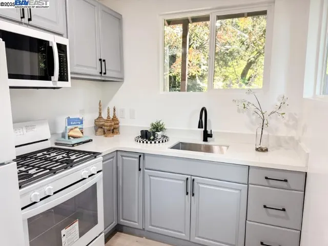 a kitchen with white cabinets and appliances