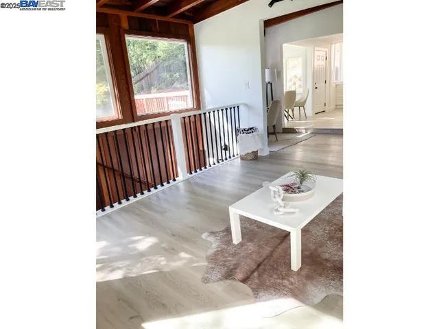 a view of a hallway with wooden floor and a room