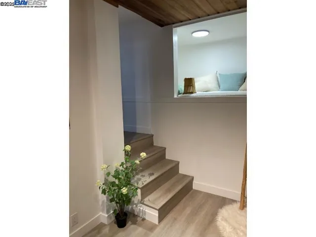 a view of a hallway with wooden floor and staircase