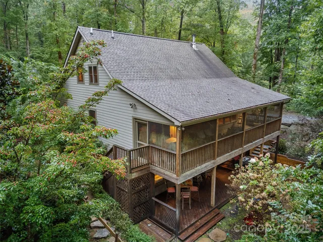 a view of house with a yard and large trees