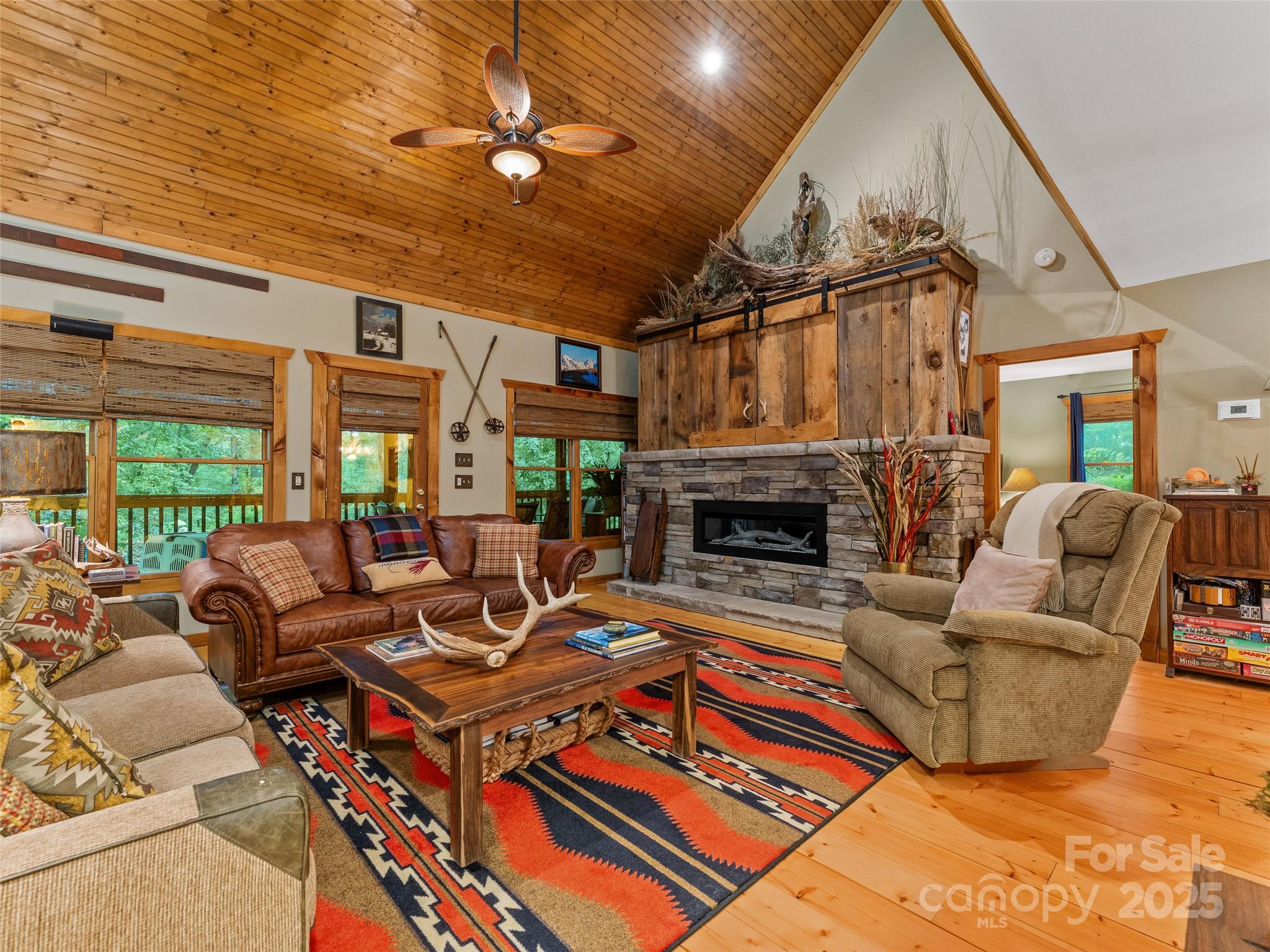 779 Thissa Way Brevard, NC 28712 - Photo 7 of 44 a living room with furniture a fireplace and a ceiling fan