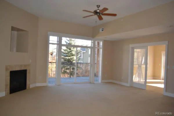 a view of n empty room with window and a fireplace
