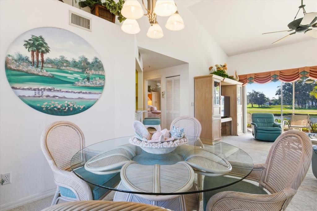 6640 Pineview Terrace, Unit 6640 Bradenton, FL 34203 - Photo 14 of 80 a view of a dining room with furniture a chandelier and wooden floor