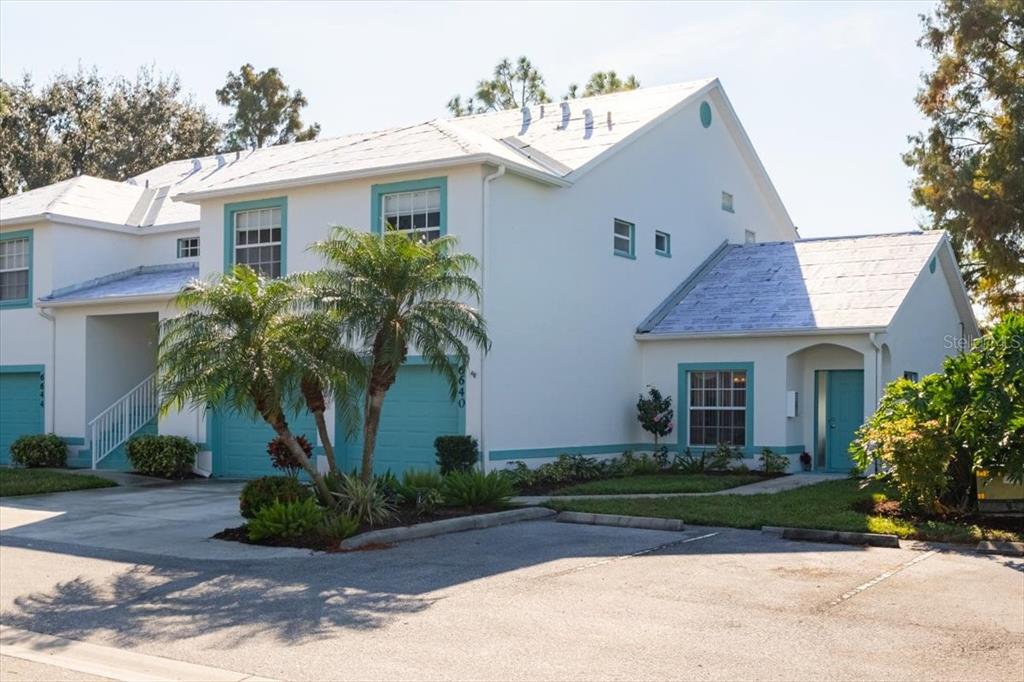 6640 Pineview Terrace, Unit 6640 Bradenton, FL 34203 - Photo 5 of 80 a front view of a house with a yard and a garage
