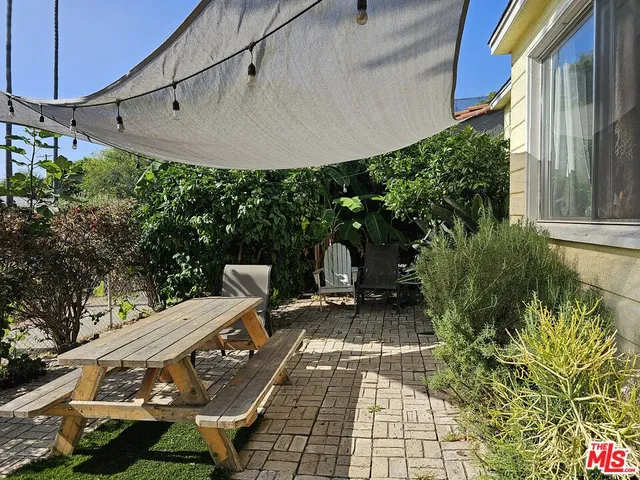 a view of a patio with table and chairs with wooden floor and plants