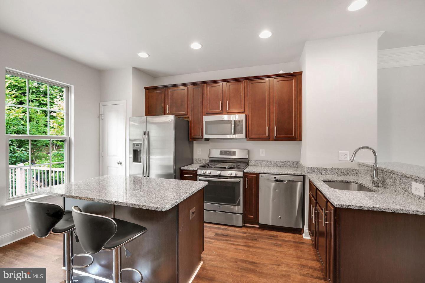 4600 Potomac Highlands Circle Triangle, VA 22172 - Photo 3 of 30 a kitchen with kitchen island granite countertop a sink dishwasher a stove and a refrigerator with wooden floor