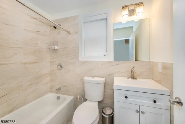 a bathroom with a sink mirror toilet and bathtub