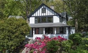 a view of a house with large windows and flower plants