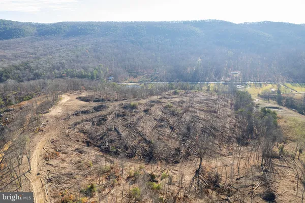 a view of a dry yard with mountains in the background