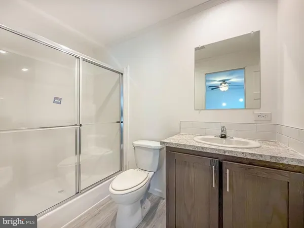 a bathroom with a granite countertop sink toilet and shower