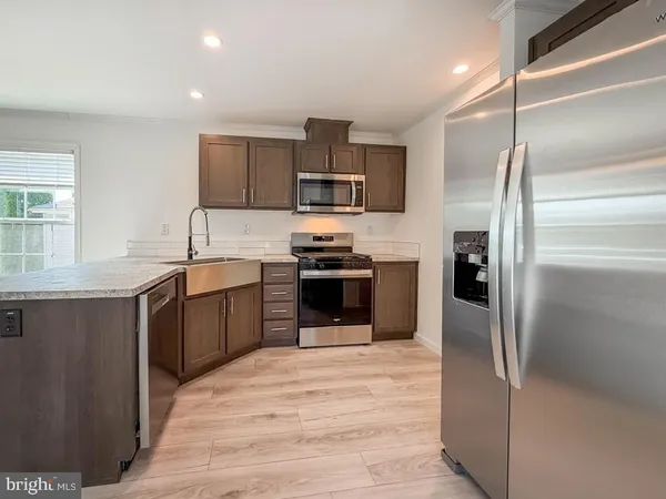 a kitchen with stainless steel appliances granite countertop a refrigerator and a sink