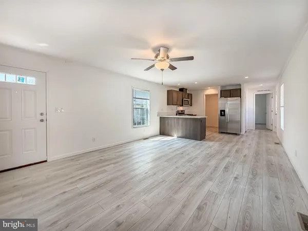 wooden floor in an empty room with a kitchen