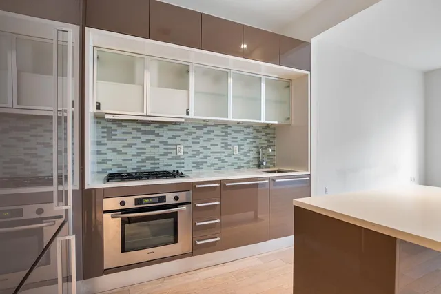 a kitchen with stainless steel appliances kitchen island wooden cabinets and a stove top oven