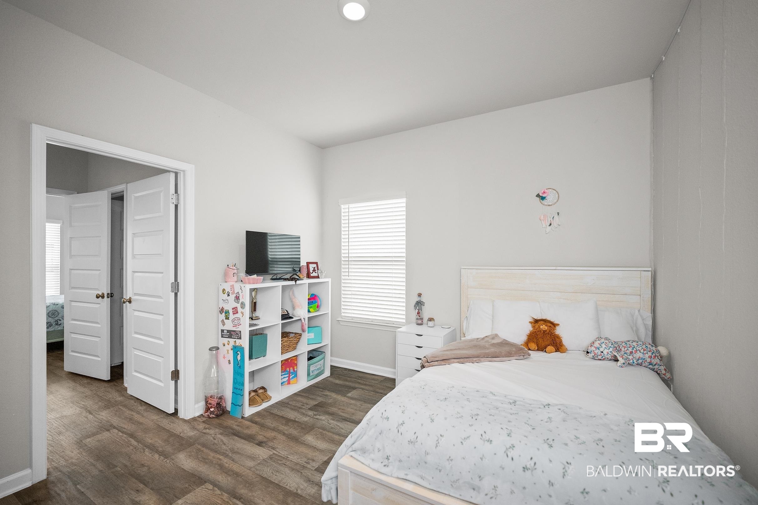23997 Veranda Circle Elberta, AL 36530 - Photo 14 of 28 Room featuring wood-finish flooring, a white headboard, and a window with horizontal blinds
