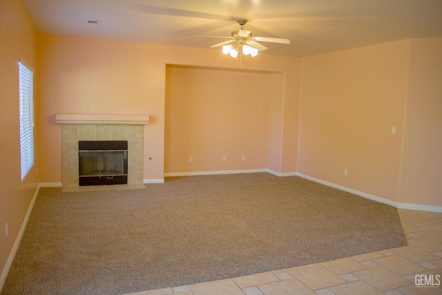 Undisclosed Address Bakersfield, CA 93312 - Photo 11 of 44 an empty room with a fireplace and fan