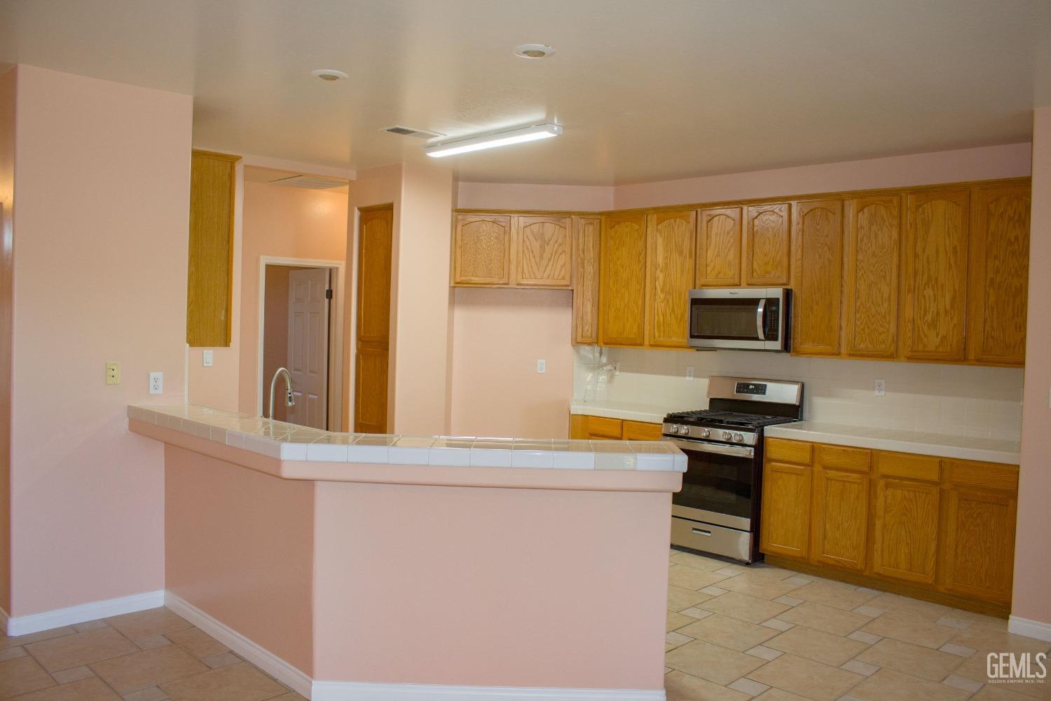 Undisclosed Address Bakersfield, CA 93312 - Photo 5 of 44 a kitchen with stainless steel appliances a stove a sink a microwave and cabinets