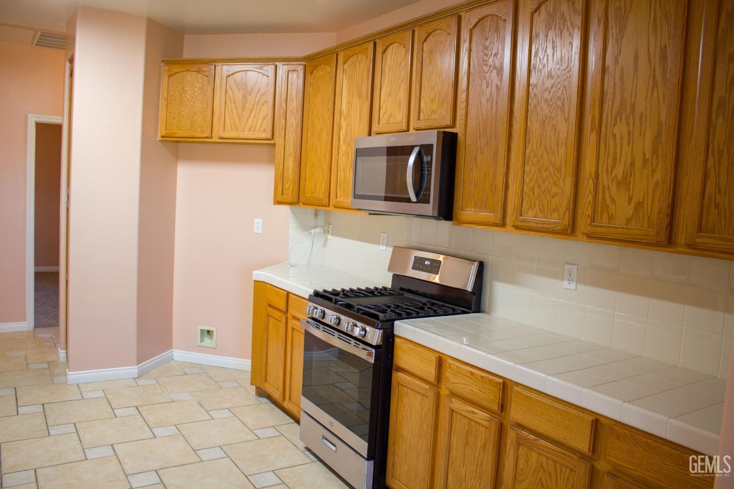 Undisclosed Address Bakersfield, CA 93312 - Photo 6 of 44 a kitchen with granite countertop cabinets stainless steel appliances a sink and a window