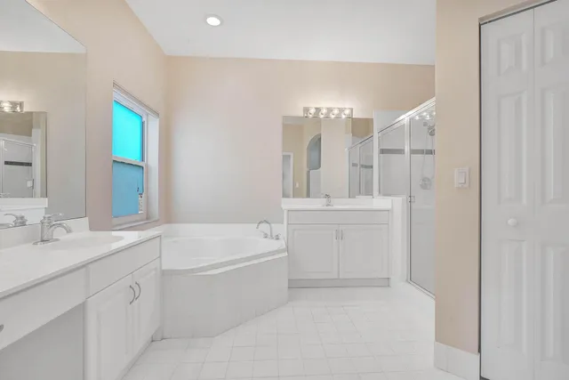 a bathroom with a tub a sink and mirror