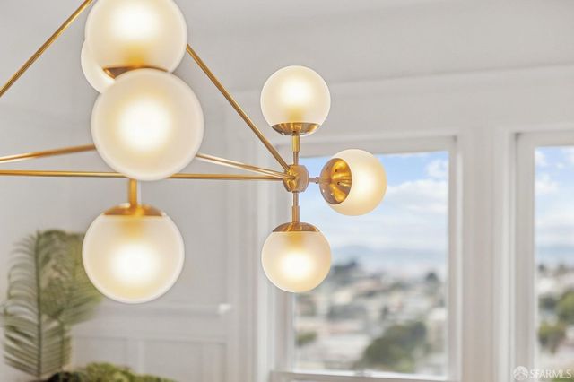 a dining room with wooden floor a chandelier a glass table and chairs