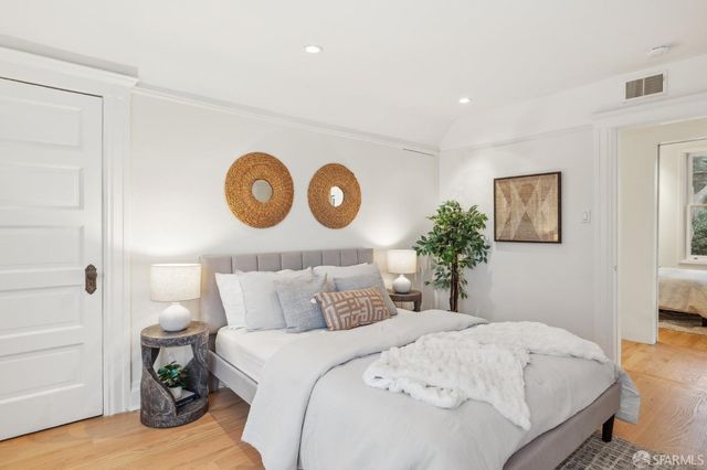 a bedroom with a bed and painting on the wall